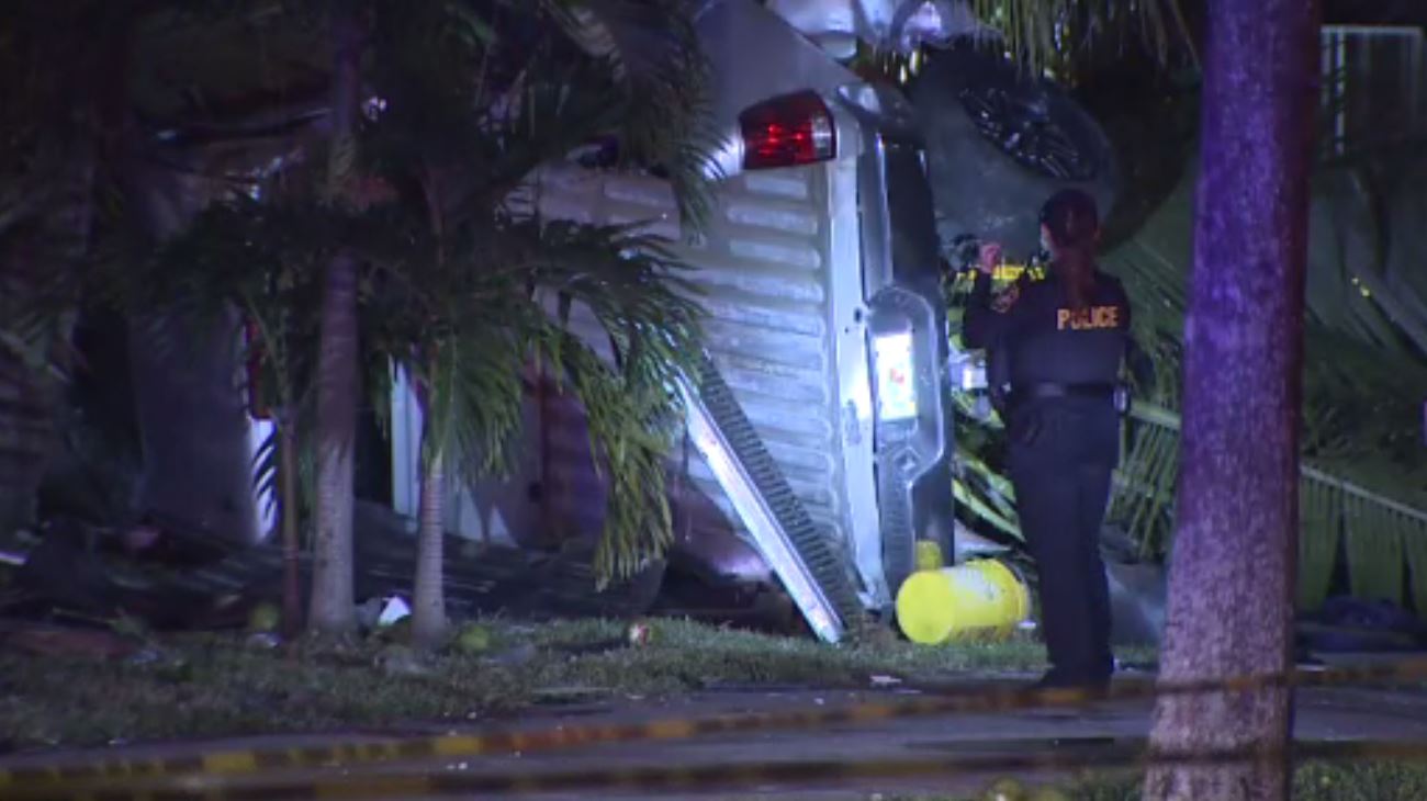 Driver hospitalized after truck flips onto yard outside Miramar home