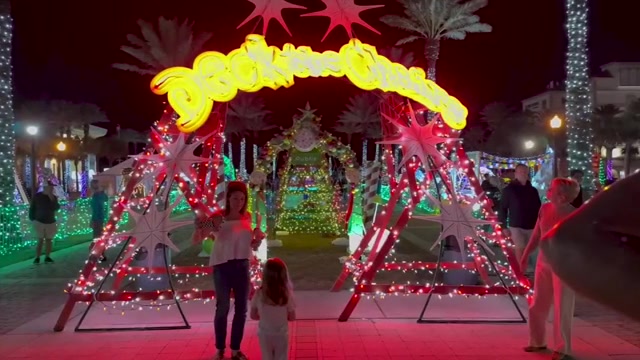 On Jacksonville Beach, lifeguard chairs are lit up alongside Christmas trees