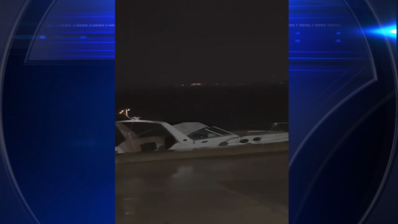 Boat washes up along seawall on Biscayne Bay due to strong winds; no one on board