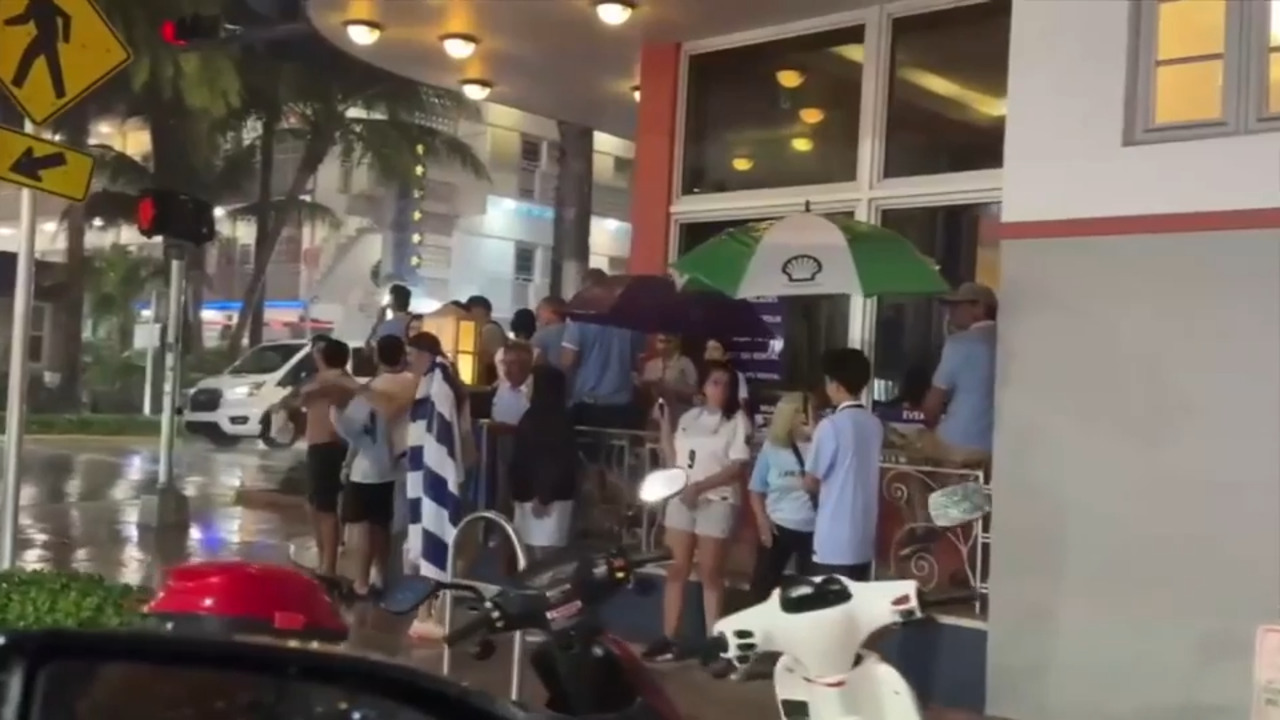 Soccer fans seek shelter from rain in South Beach ahead of celebration for FIFA World Cup matches