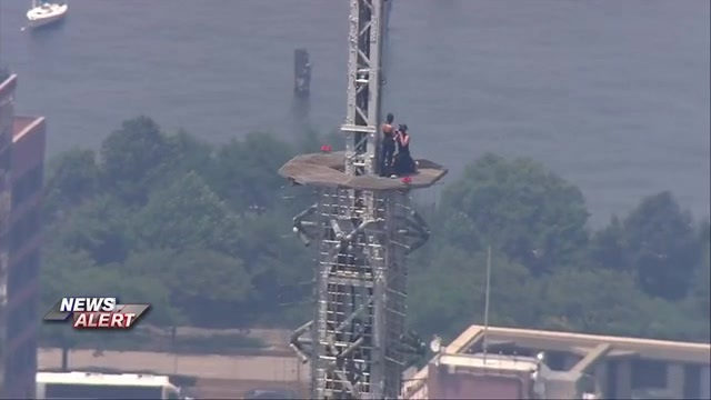 2 people hang banner about ‘the power of love’ on Empire State Building antenna